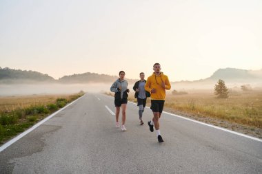 Bir grup arkadaş, sporcu ve koşucu sabahın erken saatlerinde güneşin doğuşuyla enerji dolu ve doğanın sakin güzelliğiyle çevrelenmiş bir şekilde puslu şafakta koşarken kucaklaşıyorlar.. 