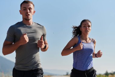 Bir çift güneş lekeli bir yolda koşar, vücutları güçlü ve sağlıklıdır, birbirlerine olan sevgileri ve her adımda aşikardır.. 