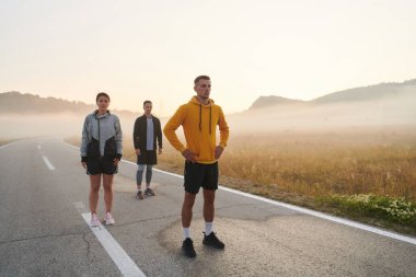Bir grup arkadaş, sporcu ve koşucu sabahın erken saatlerinde güneşin doğuşuyla enerji dolu ve doğanın sakin güzelliğiyle çevrelenmiş bir şekilde puslu şafakta koşarken kucaklaşıyorlar.. 