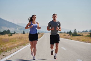 Bir çift güneş lekeli bir yolda koşar, vücutları güçlü ve sağlıklıdır, birbirlerine olan sevgileri ve her adımda aşikardır.. 