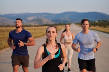 Bir grup arkadaş, güneşli bir günde dışarıda koşuşturarak sağlıklı bir yaşam tarzını sürdürüyor. Spor ve doğanın enerji verici etkilerinden keyif alıyorlar.. 