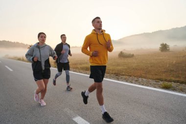 Bir grup arkadaş, sporcu ve koşucu sabahın erken saatlerinde güneşin doğuşuyla enerji dolu ve doğanın sakin güzelliğiyle çevrelenmiş bir şekilde puslu şafakta koşarken kucaklaşıyorlar.. 