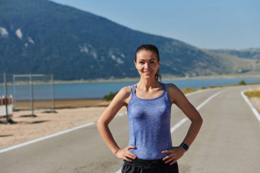 Bir kadın sporcunun dinlenirken, yoğun bir koşunun ardından terleyerek, azim ve kondisyonuna olan bağlılığını somutlaştıran, kendini adamış bir kadın sporcunun nadide görüntüsünü yakına çekiyoruz.