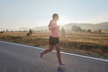 Kararlı ve motive olmuş bir sporcu gün doğumuna güvenle koşuyor, sabah koşusunda kararlılığını ve gücünü özetliyor.. 