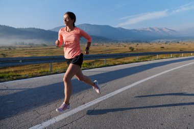 Kararlı ve motive olmuş bir sporcu gün doğumuna güvenle koşuyor, sabah koşusunda kararlılığını ve gücünü özetliyor.. 