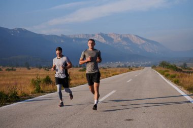 Bir grup arkadaş, güneşli bir günde dışarıda koşuşturarak sağlıklı bir yaşam tarzını sürdürüyor. Spor ve doğanın enerji verici etkilerinden keyif alıyorlar..