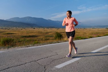 Kararlı ve motive olmuş bir sporcu gün doğumuna güvenle koşuyor, sabah koşusunda kararlılığını ve gücünü özetliyor.. 