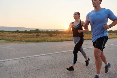 Açık havada koşan canlı bir çift atletizm ve romantizmin özünü somutlaştırıyor. Kendine güvenen adımları gelecekteki maratona ortak bir bağlılığı ve hazırlığı yansıtıyor.