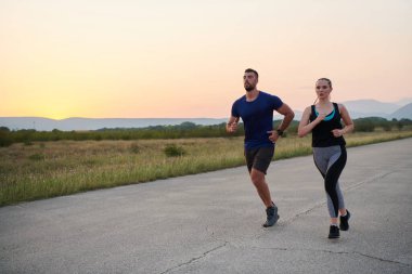 A vibrant couple dashes running the outdoors, embodying the essence of athleticism and romance, their confident strides reflecting a shared commitment to fitness and preparation for future marathon clipart