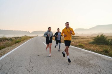 Bir grup arkadaş, sporcu ve koşucu sabahın erken saatlerinde güneşin doğuşuyla enerji dolu ve doğanın sakin güzelliğiyle çevrelenmiş bir şekilde puslu şafakta koşarken kucaklaşıyorlar.. 