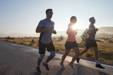 Bir grup arkadaş, sporcu ve koşucu sabahın erken saatlerinde güneşin doğuşuyla enerji dolu ve doğanın sakin güzelliğiyle çevrelenmiş bir şekilde puslu şafakta koşarken kucaklaşıyorlar.. 