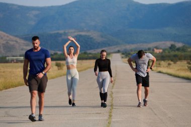 Bir grup arkadaş, güneşli bir günde dışarıda koşuşturarak sağlıklı bir yaşam tarzını sürdürüyor. Spor ve doğanın enerji verici etkilerinden keyif alıyorlar.. 