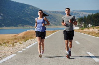 Bir çift güneş lekeli bir yolda koşar, vücutları güçlü ve sağlıklıdır, birbirlerine olan sevgileri ve her adımda aşikardır.. 