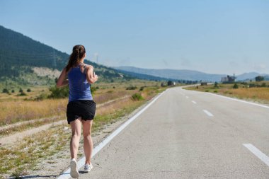 Atletik bir kadın sağlıklı bir yaşam tarzında özgürlük ve neşe bulur. Gün doğumunda güzel bir patikada koşar.. 