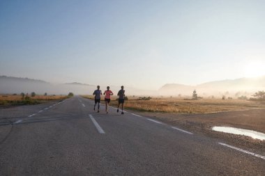 Bir grup arkadaş, sporcu ve koşucu sabahın erken saatlerinde güneşin doğuşuyla enerji dolu ve doğanın sakin güzelliğiyle çevrelenmiş bir şekilde puslu şafakta koşarken kucaklaşıyorlar.. 