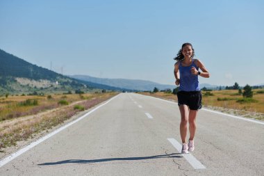 Atletik bir kadın sağlıklı bir yaşam tarzında özgürlük ve neşe bulur. Gün doğumunda güzel bir patikada koşar.. 