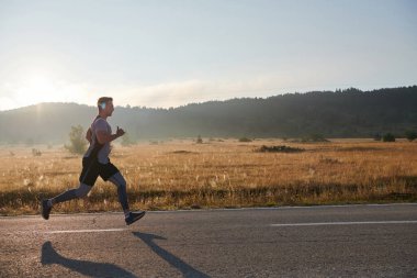 Atletik bir adam koşarken kararlılığını sergiler, sağlıklı bir yaşam tarzına ve yaklaşan maraton yarışmasına hazırlanmaya bağlıdır.