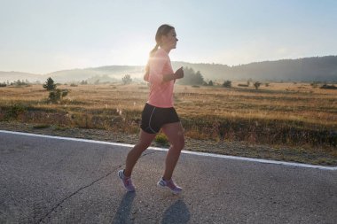 Kararlı ve motive olmuş bir sporcu gün doğumuna güvenle koşuyor, sabah koşusunda kararlılığını ve gücünü özetliyor.. 