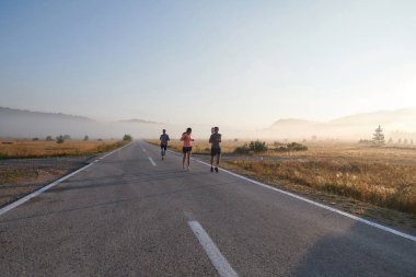 Bir grup arkadaş, sporcu ve koşucu sabahın erken saatlerinde güneşin doğuşuyla enerji dolu ve doğanın sakin güzelliğiyle çevrelenmiş bir şekilde puslu şafakta koşarken kucaklaşıyorlar.. 