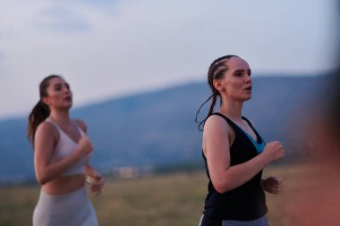 Bir grup arkadaş, güneşli bir günde dışarıda koşuşturarak sağlıklı bir yaşam tarzını sürdürüyor. Spor ve doğanın enerji verici etkilerinden keyif alıyorlar.. 