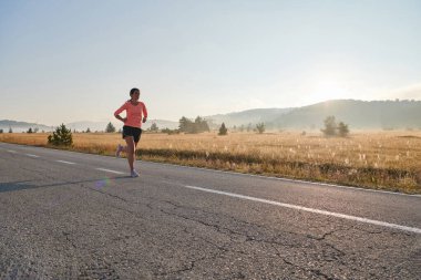 Kararlı ve motive olmuş bir sporcu gün doğumuna güvenle koşuyor, sabah koşusunda kararlılığını ve gücünü özetliyor.. 