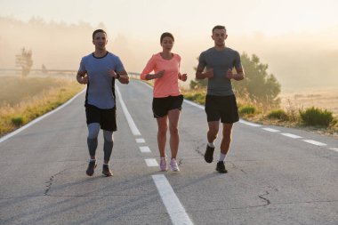 Bir grup arkadaş, sporcu ve koşucu sabahın erken saatlerinde güneşin doğuşuyla enerji dolu ve doğanın sakin güzelliğiyle çevrelenmiş bir şekilde puslu şafakta koşarken kucaklaşıyorlar.. 