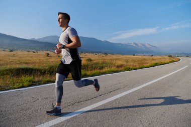 Atletik bir adam koşarken kararlılığını sergiler, sağlıklı bir yaşam tarzına ve yaklaşan maraton yarışmasına hazırlanmaya bağlıdır.