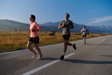 Bir grup arkadaş, güneşli bir günde dışarıda koşuşturarak sağlıklı bir yaşam tarzını sürdürüyor. Spor ve doğanın enerji verici etkilerinden keyif alıyorlar.. 