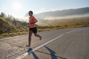 Kararlı ve motive olmuş bir sporcu gün doğumuna güvenle koşuyor, sabah koşusunda kararlılığını ve gücünü özetliyor.. 