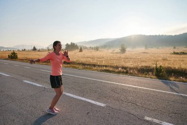  A determined athletic woman engages in post-run stretching, epitomizing dedication to her fitness journey and nurturing her bodys flexibility and well-being clipart