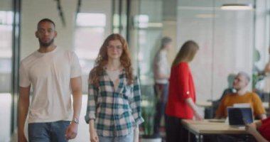 Kendine güvenen iş kadınlarından oluşan bir ekip modern bir başlangıç sahasının koridorlarında yürürken çapraz kollarla kendilerini işe adadıklarını gösteriyorlar.