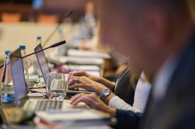 Önemli bir seminer sırasında stratejik tartışmalar ve proje planlaması yapan iş adamları, işbirlikçi karar alma sürecinde laptoplar ve kağıtlardan yararlanıyor.