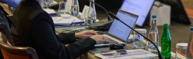 Önemli bir seminer sırasında stratejik tartışmalar ve proje planlaması yapan iş adamları, işbirlikçi karar alma sürecinde laptoplar ve kağıtlardan yararlanıyor.