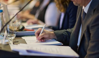 Önemli bir seminer sırasında stratejik tartışmalar ve proje planlaması yapan iş adamları, işbirlikçi karar alma sürecinde laptoplar ve kağıtlardan yararlanıyor.