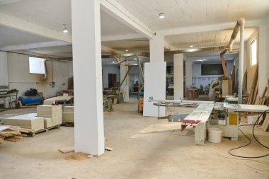 CNC kesme makinelerinin ve çeşitli ahşap işleme ekipmanlarının sergilendiği bir ahşap işleme tesisinin iç görünümü.