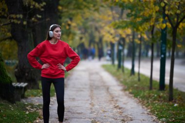Atletik genç kadın, koşudan ve esnemeden sonra nefes alıyor ve dinleniyor. Sokakta Kadın Eğitimi ve Egzersizleri. Zayıf ve formda bir kız aktif fitness eğitiminden sonra esniyor.. 