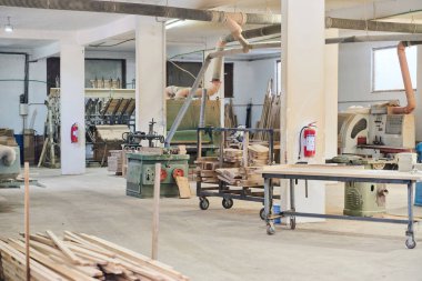 CNC kesme makinelerinin ve çeşitli ahşap işleme ekipmanlarının sergilendiği bir ahşap işleme tesisinin iç görünümü.