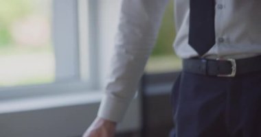 Bir yönetmen müşterisiyle olan sözleşmesini kesinleştirir, anlaşmayı sıkı bir tokalaşmayla imzalar, profesyonelliği ve modern ofis ortamındaki başarılı müşteri ilişkilerini örnek alır.