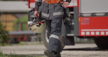 İtfaiye arabasının yanında duran özel bir itfaiye eri tehlikeli yangın senaryolarında yüksek riskli bir kurtarma görevine hazırlanıyor. Acil durumlarda hayat kurtarmaya kararlı olduğunu gösteriyor.