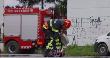 İtfaiyecilerden oluşan özel bir ekip bir itfaiye aracından hortumları alıyor ve tehlikeli bir tehlikeyle mücadele etmedeki cesaret ve profesyonel uzmanlıklarını sergileyerek, yanan bir yangını söndürmek için tehlikeli bir göreve çıkıyorlar.