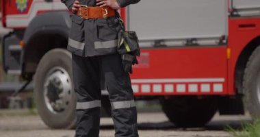 İtfaiye arabasının yanında duran özel bir itfaiye eri tehlikeli yangın senaryolarında yüksek riskli bir kurtarma görevine hazırlanıyor. Acil durumlarda hayat kurtarmaya kararlı olduğunu gösteriyor.