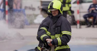 İtfaiyecilerden oluşan özel bir ekip bir itfaiye aracından hortumları alıyor ve tehlikeli bir tehlikeyle mücadele etmedeki cesaret ve profesyonel uzmanlıklarını sergileyerek, yanan bir yangını söndürmek için tehlikeli bir göreve çıkıyorlar.