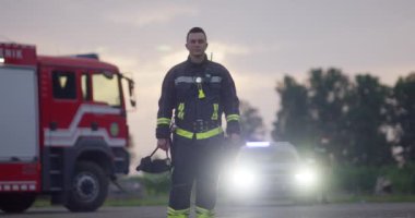 Koruyucu kıyafetli kahraman bir itfaiyecinin portresi. İtfaiyeci itfaiyecisi ya da gece veya gündüz araba kazası kurtarma operasyonu. Yüksek kalite fotoğraf