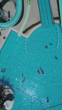 Güneşli yaz günlerinde güneşlenmeyi ve dinlenmeyi, mavi su havuzlarında yüzmeyi, havadan çekim yapmayı seven insanların en iyi görüntüsü. Yüksek kalite 4k dikey görüntü