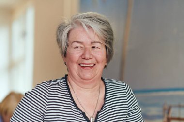 Güneşli bir ortamda, son sınıf bir kadın zarif bir şekilde yogayı gençleştirir, boyun, sırt ve bacak hareketlerine odaklanır, dinginliği ve refahı somutlaştırır.. 