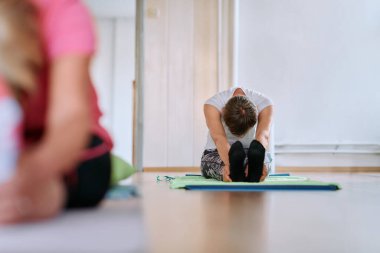 Son sınıf öğrencisi bir kadın güneşli bir odada esneyerek esnekliğini arttırıyor ve sağlıklı, aktif bir yaşam tarzını teşvik ediyor..