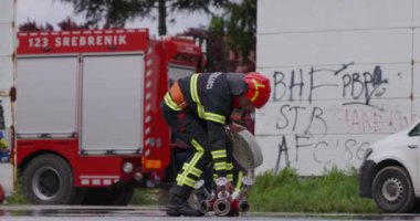 İtfaiyecilerden oluşan özel bir ekip bir itfaiye aracından hortumları alıyor ve tehlikeli bir tehlikeyle mücadele etmedeki cesaret ve profesyonel uzmanlıklarını sergileyerek, yanan bir yangını söndürmek için tehlikeli bir göreve çıkıyorlar.