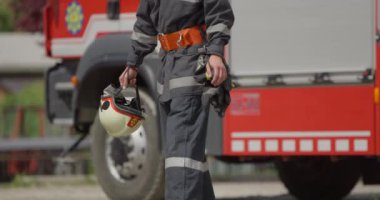 İtfaiye arabasının yanında duran özel bir itfaiye eri tehlikeli yangın senaryolarında yüksek riskli bir kurtarma görevine hazırlanıyor. Acil durumlarda hayat kurtarmaya kararlı olduğunu gösteriyor.