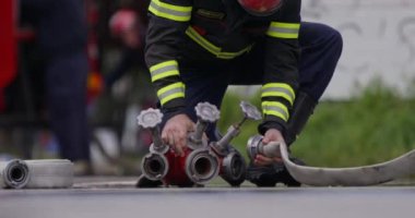 İtfaiyecilerden oluşan özel bir ekip bir itfaiye aracından hortumları alıyor ve tehlikeli bir tehlikeyle mücadele etmedeki cesaret ve profesyonel uzmanlıklarını sergileyerek, yanan bir yangını söndürmek için tehlikeli bir göreve çıkıyorlar.