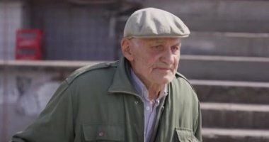 Yakın çekim, sohbete dalmış yaşlı bir adamı yakalıyor, puro içiyor, eski bir şapkayla spor yapıyor, bilgelik ve karakter duygusu yayıyor.. 
